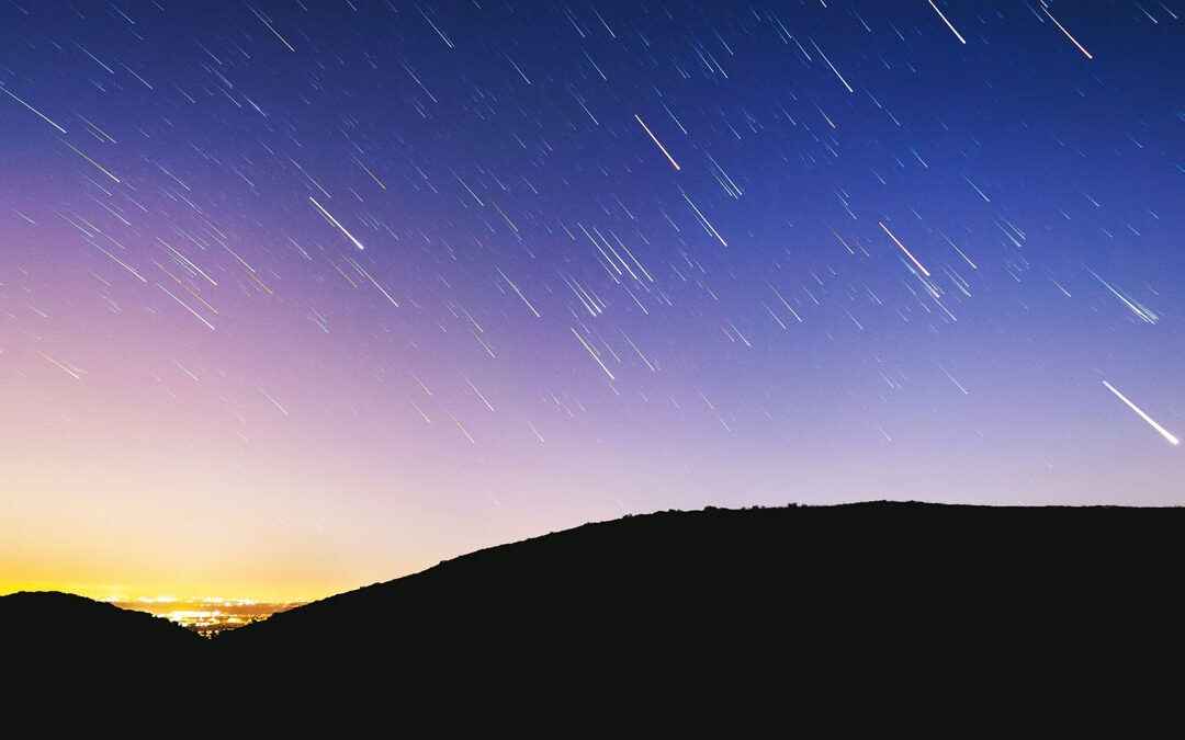 A long exposure of a clear night sky with meteor shower streaks by Austin Schmid